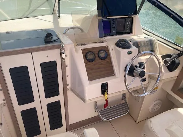 Slide: The Image of 1997 Grady-White 232 Gulfstream boat cockpit with steering wheel and navigation instruments. - 5