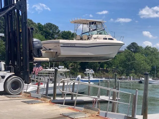 Slide: The Image of 1997 Grady-White 232 Gulfstream boat lifted by forklift at marina. - 8