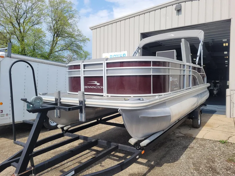 Slide: The Image of 2020 Bennington 22 SSBXP pontoon boat on trailer outside a garage. - 0