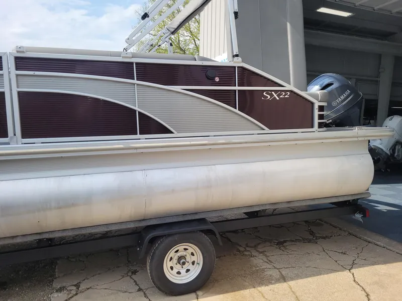 Slide: The Image of 2020 Bennington 22 SSBXP pontoon boat on trailer, parked outside a garage. - 12