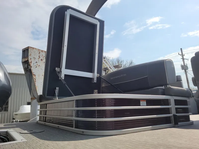Slide: The Image of 2020 Bennington 22 SSBXP pontoon boat with seating and railing, under a clear sky. - 13