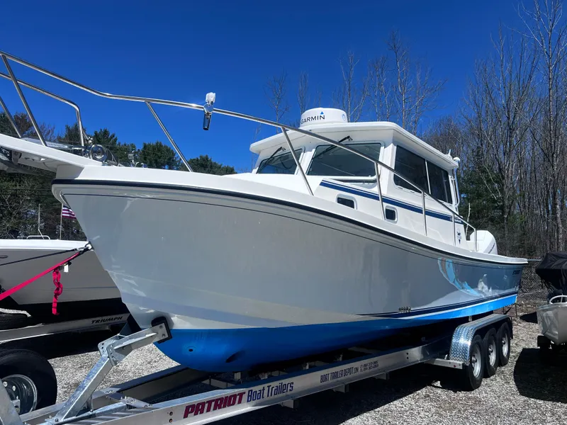 Slide: The Image of 2022 Steiger Craft 31 Chesapeake boat on trailer, displayed outdoors under clear blue sky. - 1