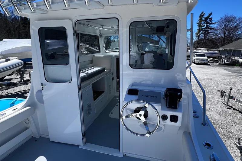 Slide: The Image of 2022 Steiger Craft 31 Chesapeake boat interior with steering wheel and cabin view. - 14