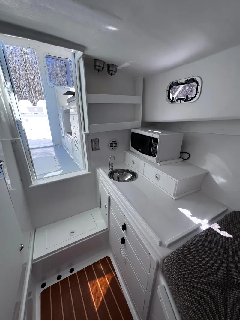 Slide: The Image of 2022 Steiger Craft 31 Chesapeake cabin interior with kitchenette, sink, and microwave. - 18