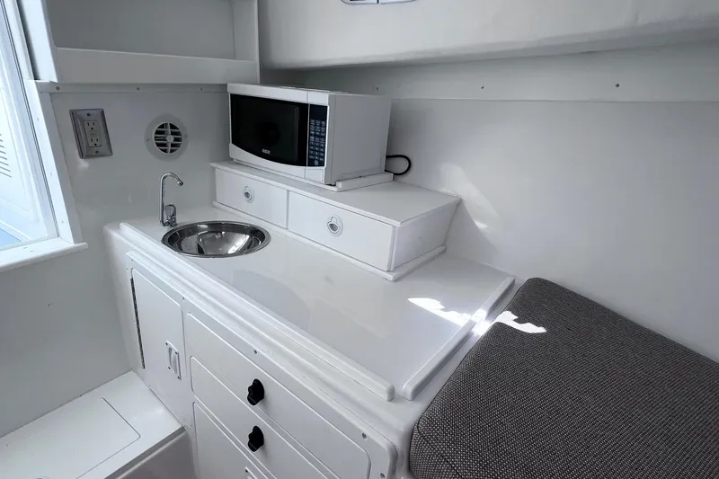 Slide: The Image of 2022 Steiger Craft 31 Chesapeake interior with sink, microwave, and storage. - 19