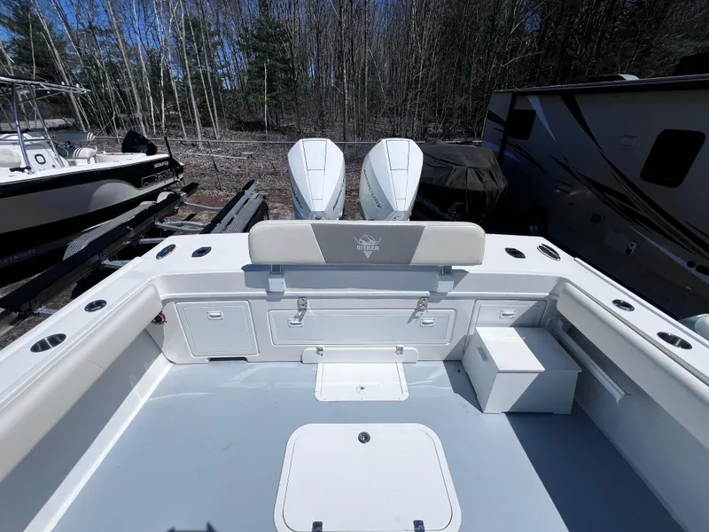 Slide: The Image of 2022 Steiger Craft 31 Chesapeake boat deck with twin engines, surrounded by trees and trailers. - 7