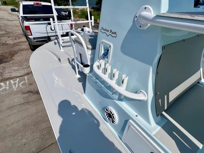 Slide: The Image of 2022 Shallow Sport 20 Classic boat with rod holders and a white pickup truck in the background. - 12