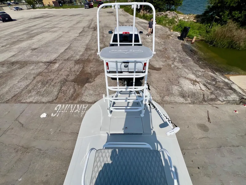 Slide: The Image of 2022 Shallow Sport 20 Classic boat on trailer at a lakeside parking area. - 13