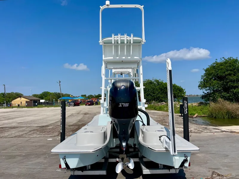 Slide: The Image of 2022 Shallow Sport 20 Classic boat with outboard motor, docked under clear blue sky. - 3