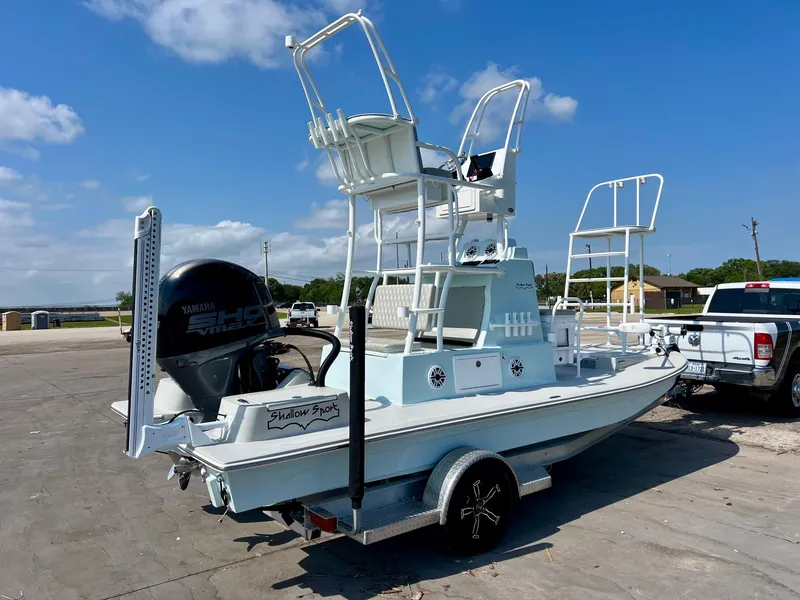 Slide: The Image of 2022 Shallow Sport 20 Classic boat with elevated seating, parked on a trailer under a clear sky. - 4