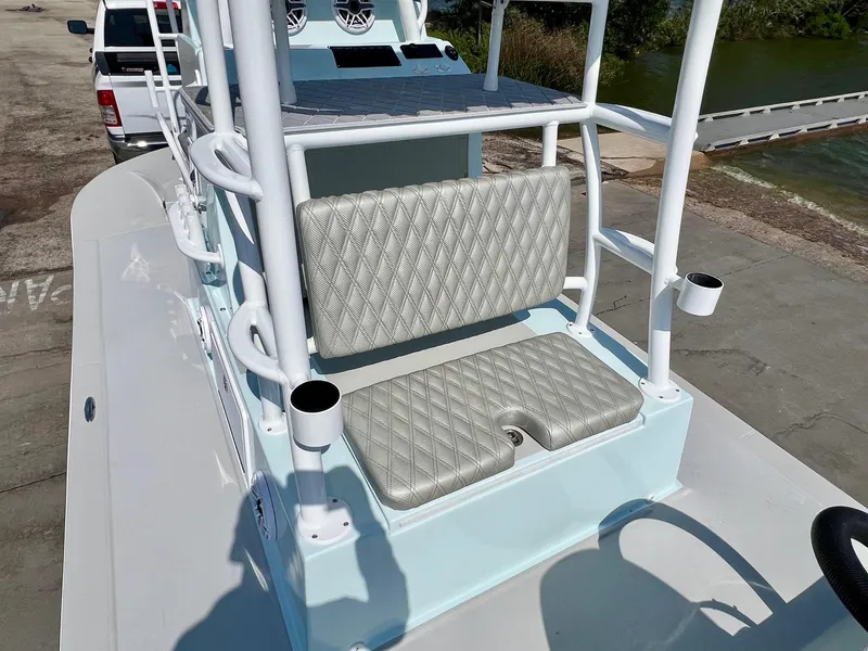 Slide: The Image of 2022 Shallow Sport 20 Classic boat with cushioned seating and rod holders, docked near water. - 8