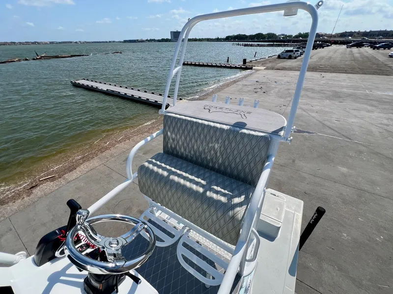 Slide: The Image of 2022 Shallow Sport 20 Classic boat at dockside with steering wheel and seating, overlooking water. - 9