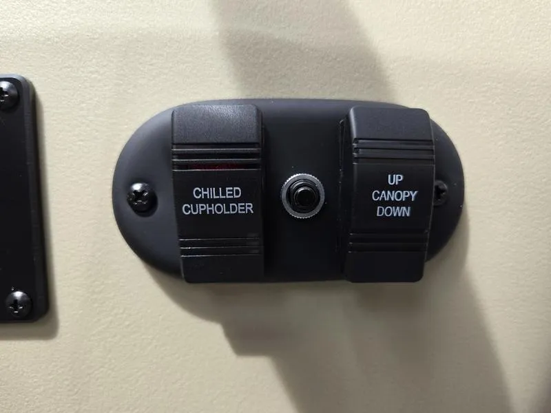 Slide: The Image of Control panel with chilled cupholder and canopy switches on 2025 Godfrey Sweetwater 2286 QS boat. - 6