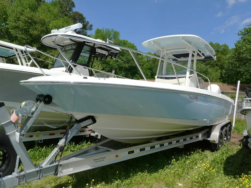 The Image of 2022 Boston Whaler 270 Dauntless boat on trailer, surrounded by greenery. - 0