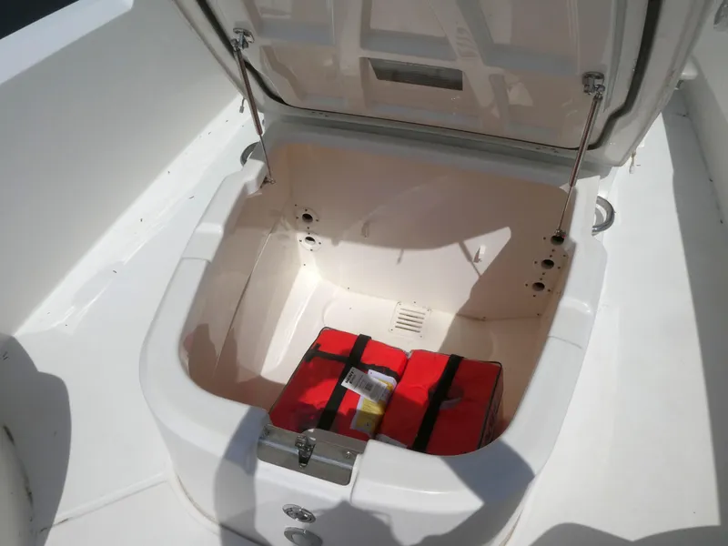 Slide: The Image of Open storage compartment on 2022 Boston Whaler 270 Dauntless boat with red life jackets. - 11