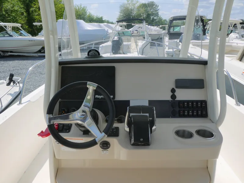 Slide: The Image of 2022 Boston Whaler 270 Dauntless helm with steering wheel and control panel. - 7