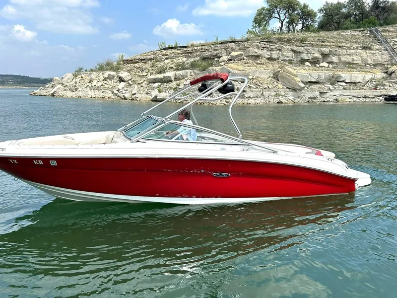 Slide: The Image of Red 2004 Sea Ray 240 Select boat on a lake with rocky shoreline background. - 13