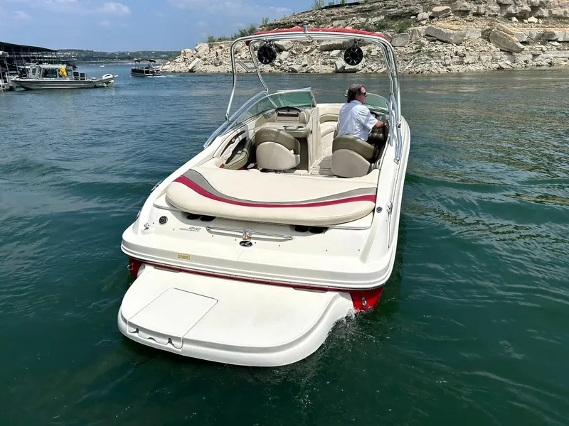 Slide: The Image of 2004 Sea Ray 240 Select boat cruising on a lake with scenic rocky shoreline. - 3