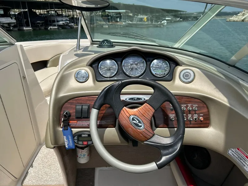 Slide: The Image of 2004 Sea Ray 240 Select boat dashboard with steering wheel and gauges, docked at marina. - 30