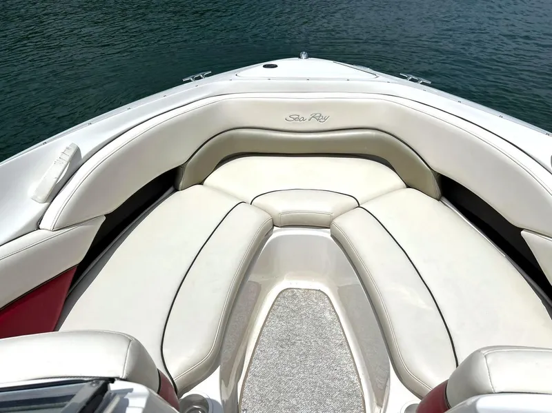 Slide: The Image of 2004 Sea Ray 240 Select boat interior with white cushioned seating and water view. - 4