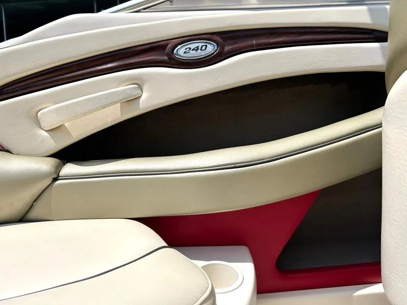 Slide: The Image of Interior of a 2004 Sea Ray 240 Select boat, featuring beige and red upholstery. - 42
