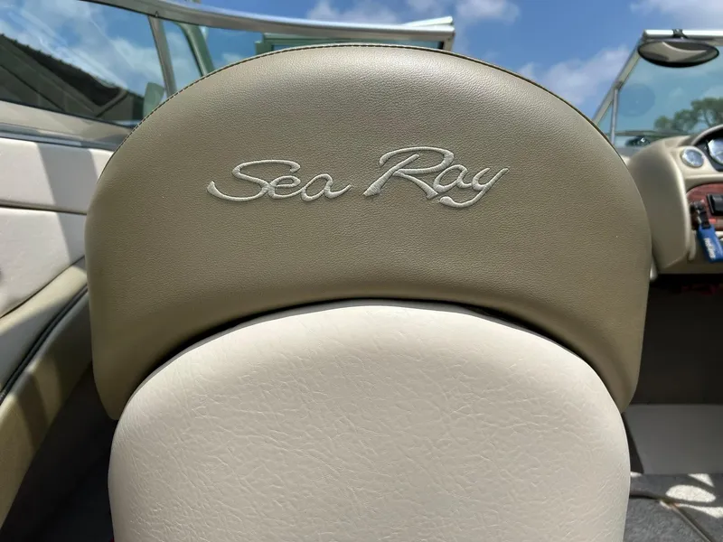 Slide: The Image of 2004 Sea Ray 240 Select boat seat with logo, sunny day, clear sky. - 47