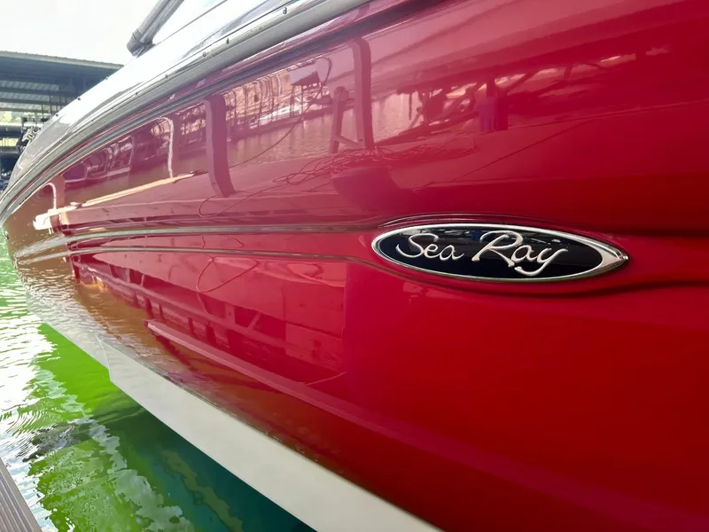 Slide: The Image of Red 2004 Sea Ray 240 Select boat docked, showcasing sleek design and logo. - 48