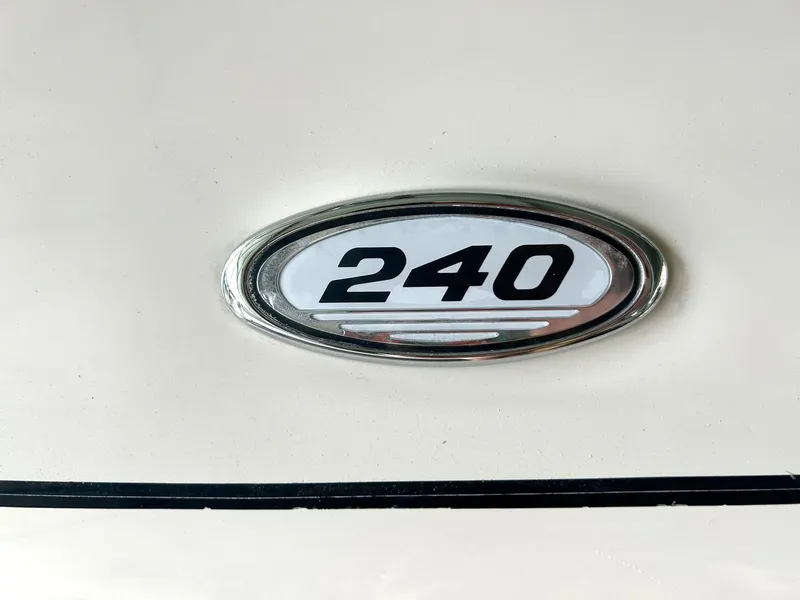Slide: The Image of Sea Ray 240 Select 2004 model emblem on white surface. - 49