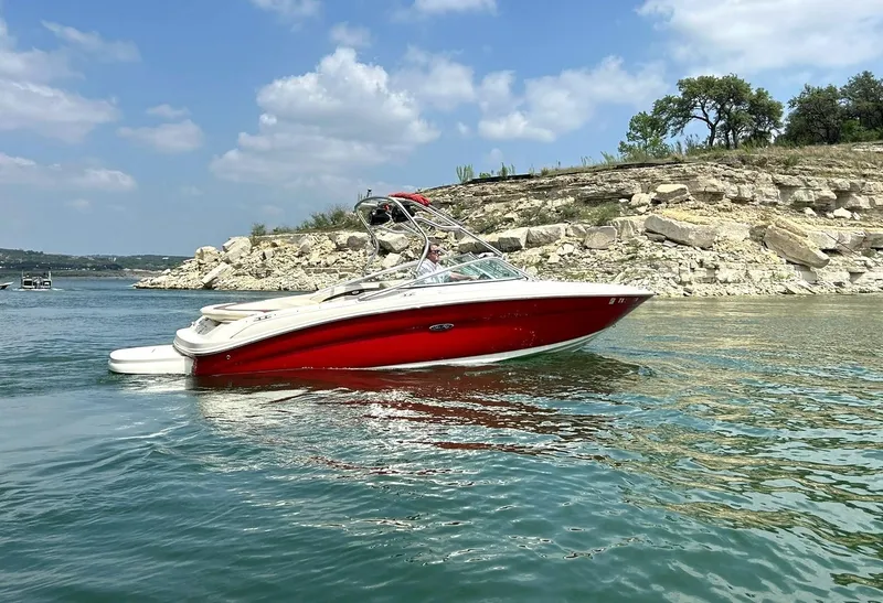Slide: The Image of 2004 Sea Ray 240 Select boat on a scenic lake with rocky shoreline. - 6