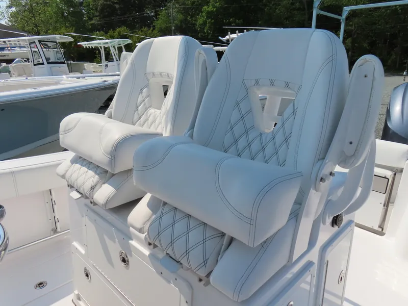 Slide: The Image of Luxurious seating on 2021 Sportsman Open 282 Center Console boat, featuring white cushioned chairs. - 26