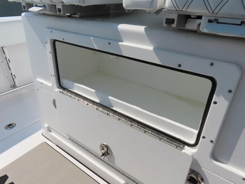 Slide: The Image of 2021 Sportsman Open 282 Center Console storage compartment, open and empty, with white interior. - 28