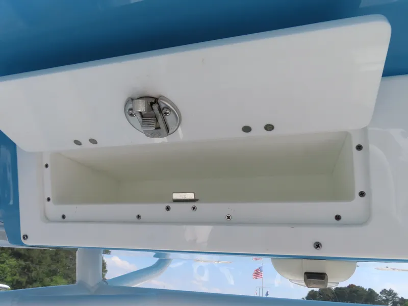 Slide: The Image of Storage compartment on a 2021 Sportsman Open 282 Center Console boat, featuring a secure latch. - 35
