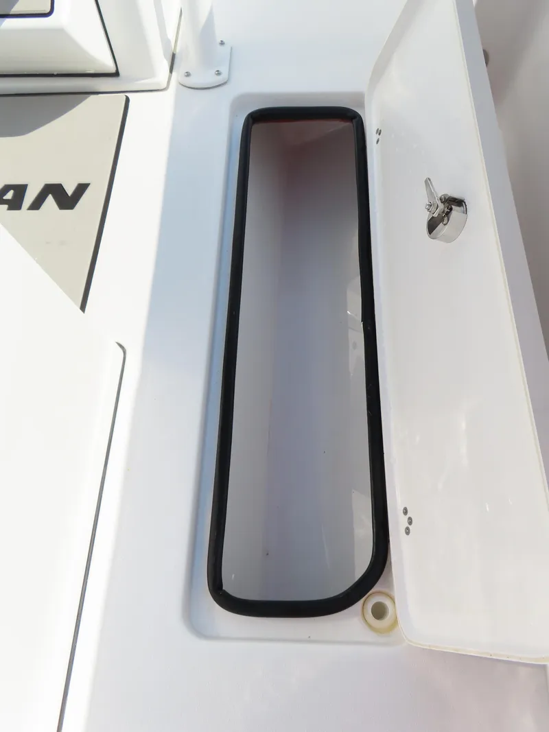 Slide: The Image of 2021 Sportsman Open 282 Center Console storage compartment with open hatch and secure latch. - 37