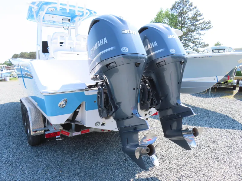 Slide: The Image of 2021 Sportsman Open 282 Center Console with dual Yamaha 300 engines, parked on gravel. - 4