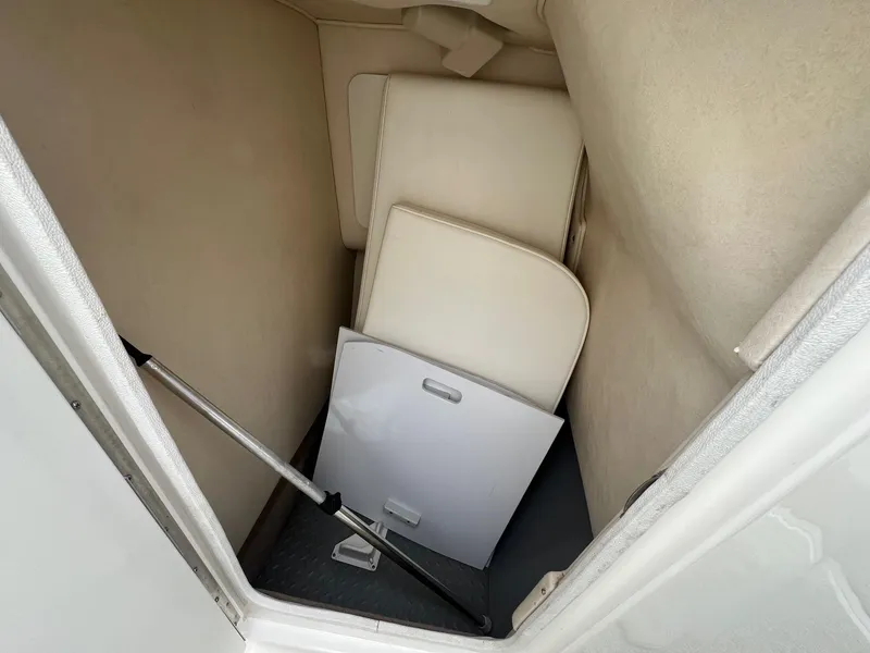 Slide: The Image of Storage compartment in 2003 Sea Ray 290 Bowrider with white panels and metal rod. - 15