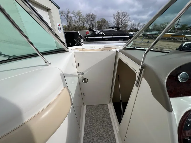 Slide: The Image of 2003 Sea Ray 290 Bowrider interior with open cabin door and seating area. - 16