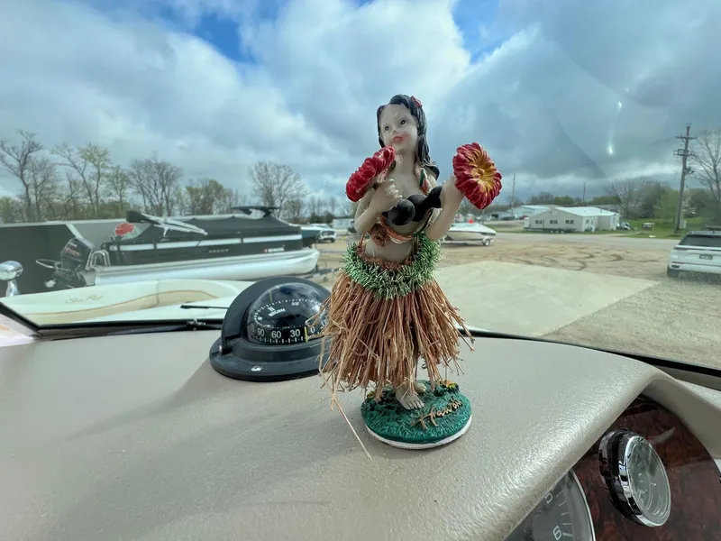 Slide: The Image of Dashboard hula dancer figurine on 2003 Sea Ray 290 Bowrider boat, with cloudy sky background. - 18