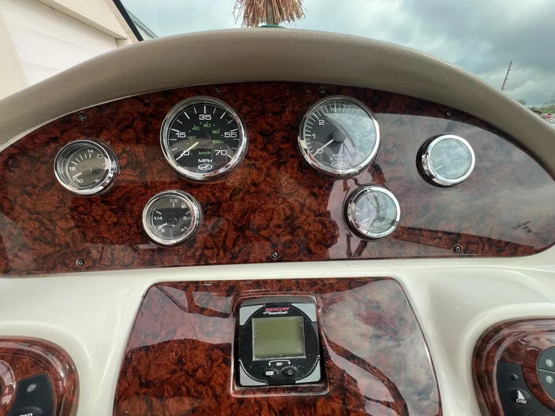 Slide: The Image of Dashboard of a 2003 Sea Ray 290 Bowrider with wood grain finish and gauges. - 19