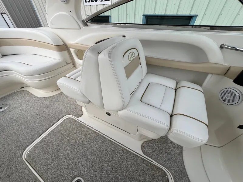 Slide: The Image of 2003 Sea Ray 290 Bowrider interior with white leather seating and carpeted flooring. - 27