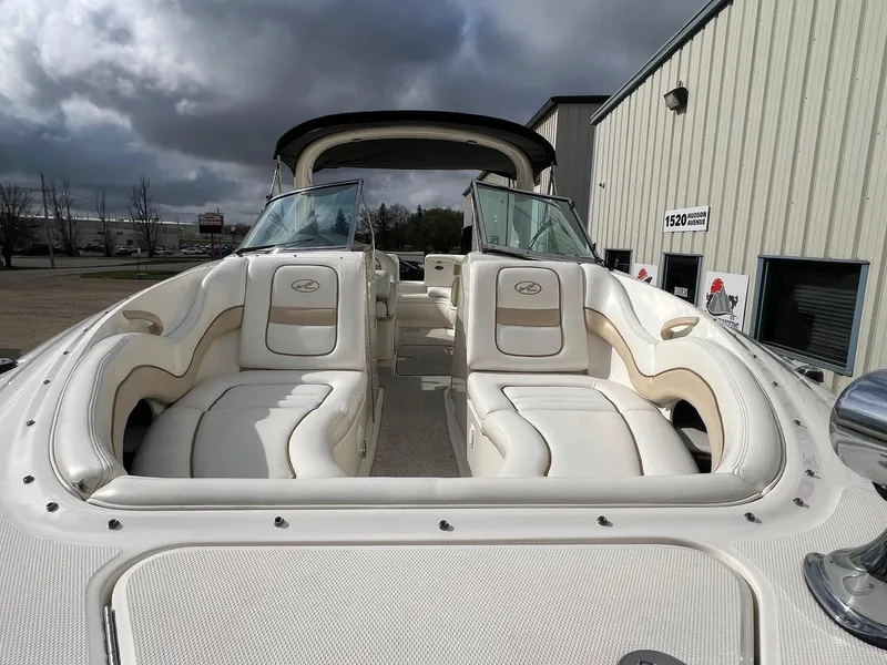 Slide: The Image of 2003 Sea Ray 290 Bowrider boat with luxurious seating, parked outdoors under cloudy skies. - 3