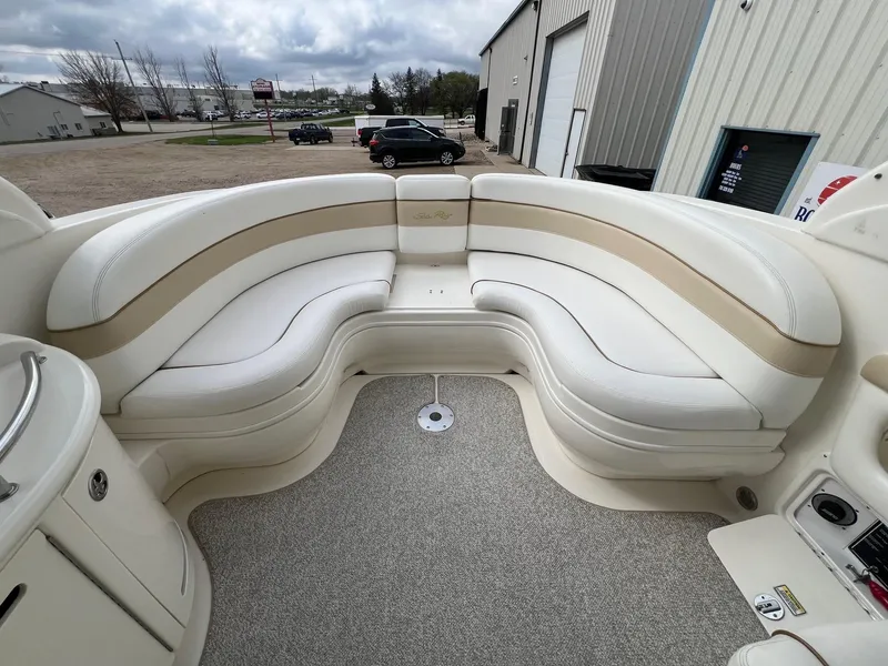 Slide: The Image of 2003 Sea Ray 290 Bowrider interior with curved seating and beige upholstery. - 35