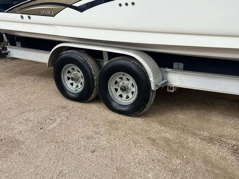 Slide: The Image of Trailer with dual wheels for 2003 Sea Ray 290 Bowrider boat on gravel surface. - 39