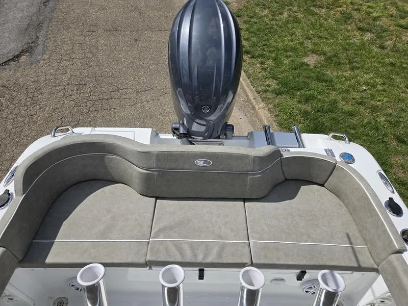 Slide: The Image of 2025 Sea Hunt Ultra 219 boat with cushioned seating and outboard motor. - 1