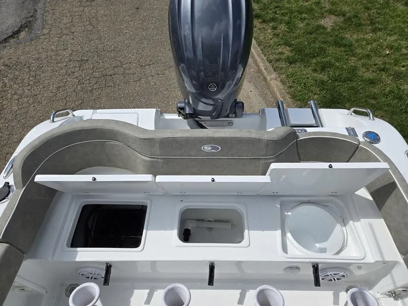 Slide: The Image of 2025 Sea Hunt Ultra 219 boat with open storage compartments and motor, viewed from above. - 10