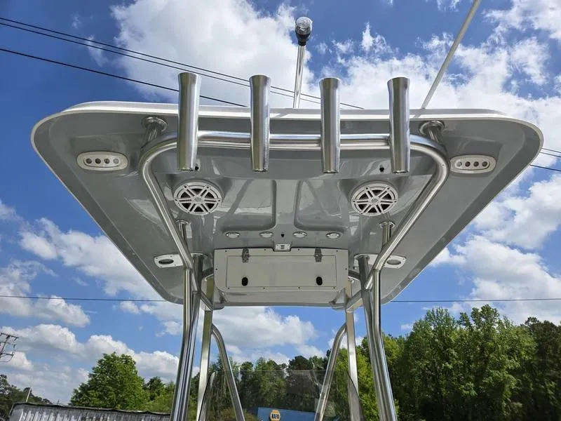 Slide: The Image of 2025 Sea Hunt Ultra 219 boat top view with rod holders and speakers under a blue sky. - 11