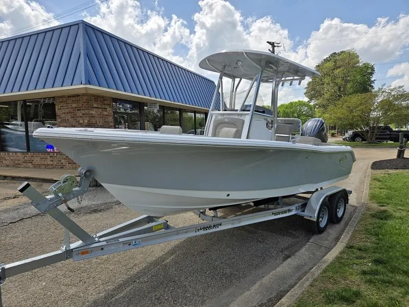 Slide: The Image of 2025 Sea Hunt Ultra 219 boat on trailer, parked near a building under a cloudy sky. - 15