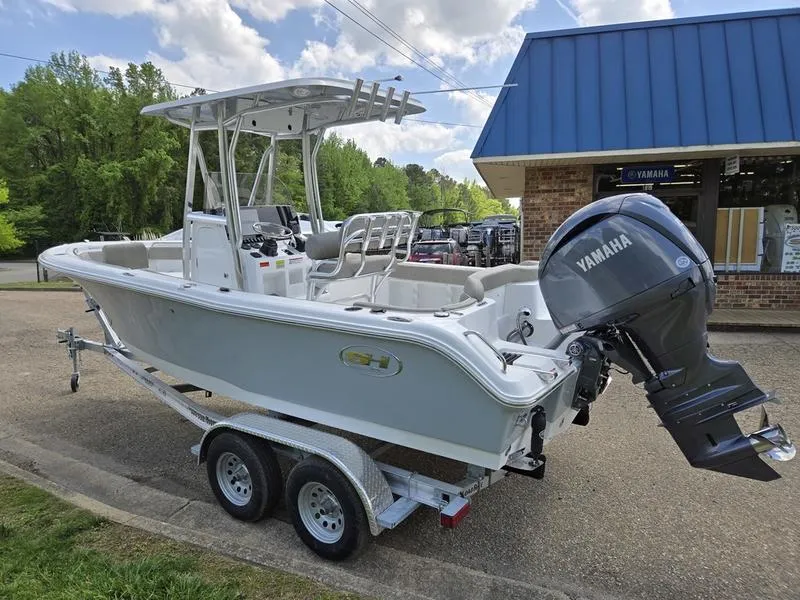 Slide: The Image of 2025 Sea Hunt Ultra 219 boat with Yamaha engine on trailer, parked outside a building. - 16