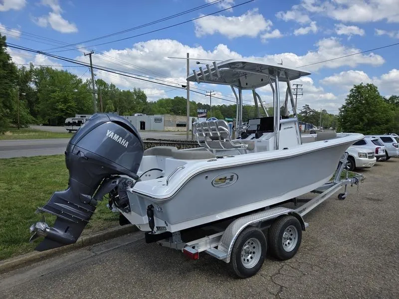 Slide: The Image of 2025 Sea Hunt Ultra 219 boat on trailer with Yamaha outboard motor, parked outdoors. - 17