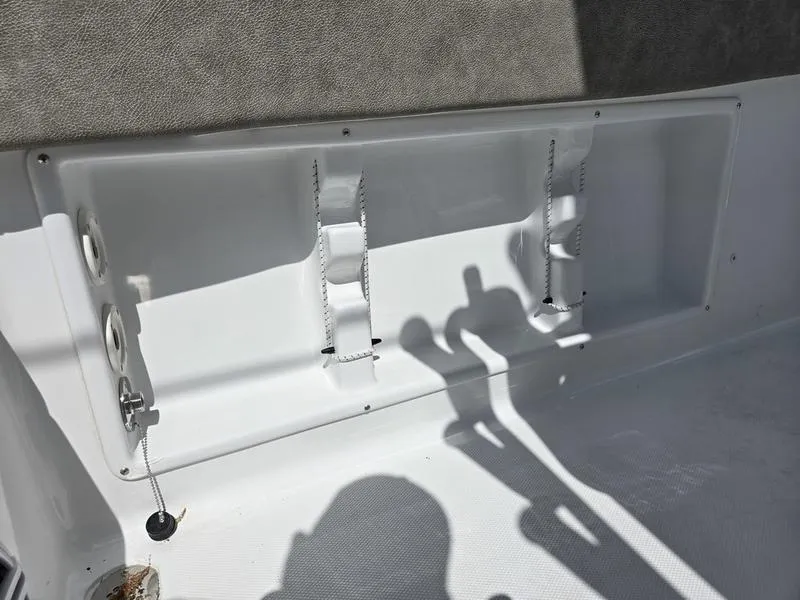 Slide: The Image of 2025 Sea Hunt Ultra 219 boat interior storage compartment with rod holders. - 3