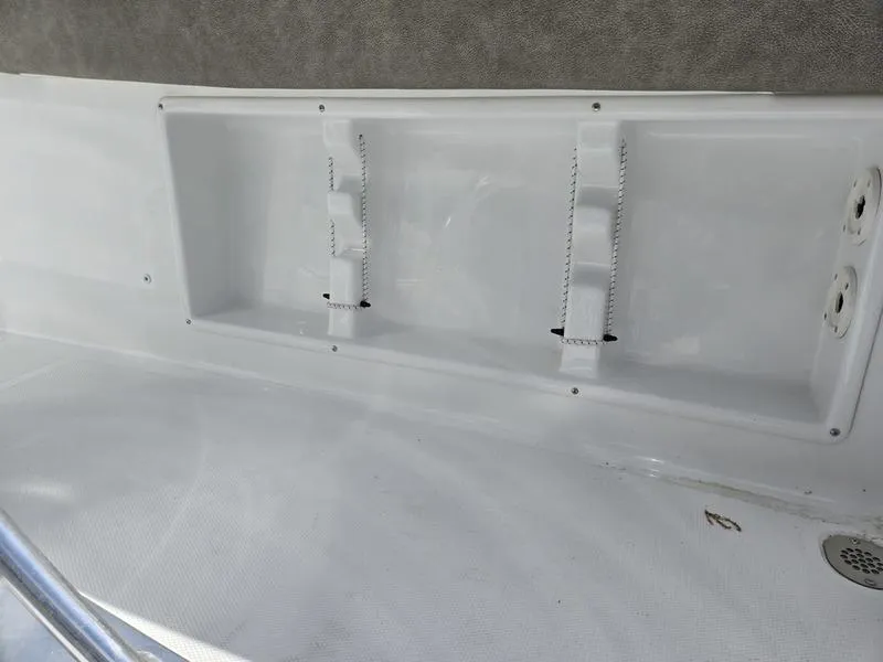 Slide: The Image of Storage compartment on a 2025 Sea Hunt Ultra 219 boat, featuring white interior and straps. - 4